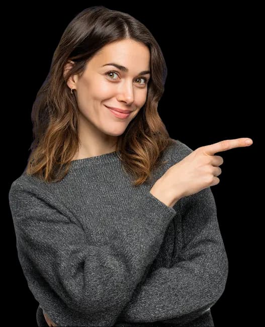 Kobieta w szarym swetrze uśmiecha się i wskazuje palcem w prawo.