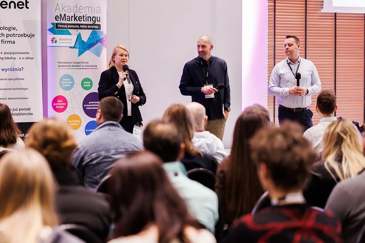 Prelegenci prowadzą prezentację na konferencji marketingowej, stojąc przed publicznością